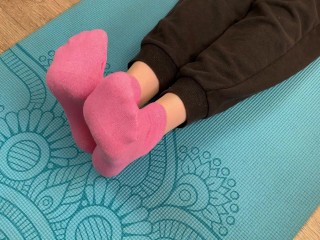 Fitness girl does exercises on the mat in socks and gives a footjob to her trainer with cum on her f