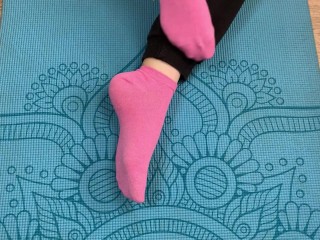 Fitness girl does exercises on the mat in socks and gives a footjob to her trainer with cum on her f