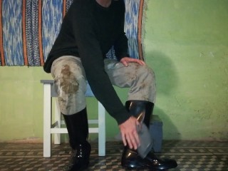 Farm man takes care of his rubber boots at the end of the day