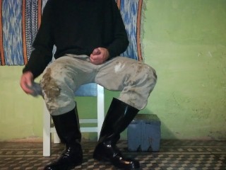 Farm man takes care of his rubber boots at the end of the day