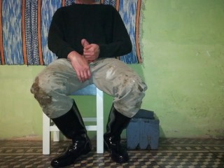 Farm man takes care of his rubber boots at the end of the day