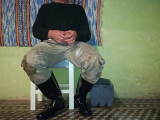 Farm man takes care of his rubber boots at the end of the day