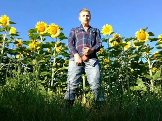 Farm man in rubber boots peeing and masturbating in the sunflower field