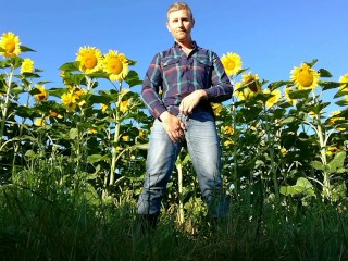 Farm man in rubber boots peeing and masturbating in the sunflower field