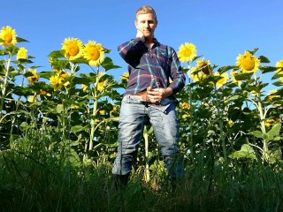 Farm man in rubber boots peeing and masturbating in the sunflower field