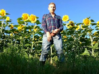 Farm man in rubber boots peeing and masturbating in the sunflower field