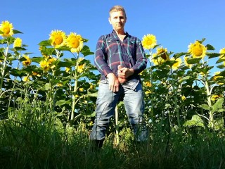 Farm man in rubber boots peeing and masturbating in the sunflower field