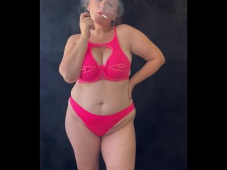 Sexy chubby girl in pink lingerie smoking