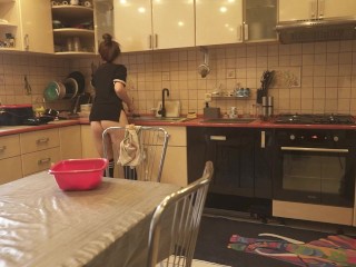 Sexy dressed wife preparing food in the kitchen