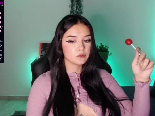 Cute college girl with a cute face looks very sexy while sucking a lollipop