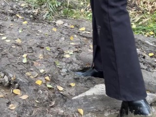 girl in high-heeled boots wants to go to home, but there is dirty slippery slide on the way