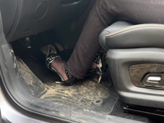 A girl in high-heeled shoes likes to listen to the sound of the engine and press the pedals with her