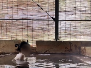 Japanese girl bathing in a mixed outdoor bath at a hot spring inn