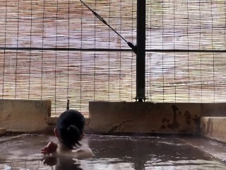 Japanese girl bathing in a mixed outdoor bath at a hot spring inn