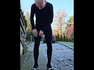 solo guy in tights peeing outside in his garden on a cold day