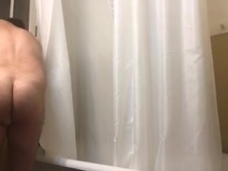 Showering guy in old fashioned tub wearing Mardi Gras beads