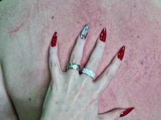 Fetish of long sharp red nails. Dominatrix scratches slave's back.