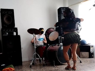 They play the drums for her - she dances, stripping and showing her ass