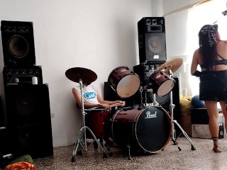 They play the drums for her - she dances, stripping and showing her ass
