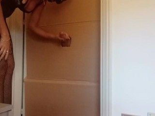 In a nylon catsuit and high heels I suck a cock and fuck it in a gloryhole until it cums in my mouth