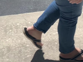 Female friend feet in flip flops coming to see me in public, in motion view