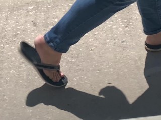 Female friend feet in flip flops coming to see me in public, in motion view