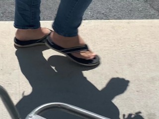 Female friend feet in flip flops coming to see me in public, in motion view