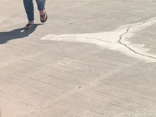 Female friend feet in flip flops coming to see me in public, in motion view