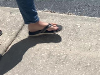 Female friend feet in flip flops coming to see me in public, in motion view