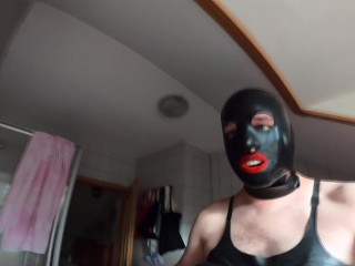 Gummipuppe im Spiegel mit Rubberfinest Mundknebel Maske Latextitten Korsett