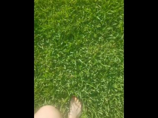 Sexy barefoot teen walks through grass 