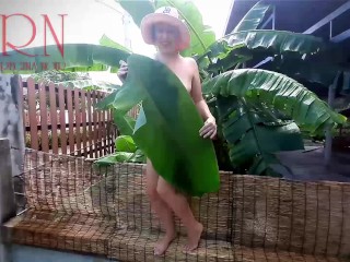 Rural striptease. Country girl dancing in the yard of her house Rustic striptease with banana leaf