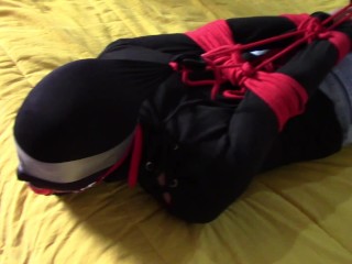 Laura XXX is wearing panthyhose and high heels. She's hogtied, masked, blindfolded and ballgagged