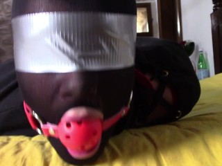 Laura XXX is wearing panthyhose and high heels. She's hogtied, masked, blindfolded and ballgagged