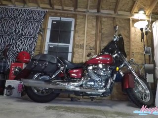 Long legged blonde lifts skirt to take a good piss in her garage next to her Harley