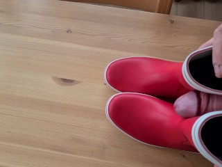 Cumming on her red rubberboots 