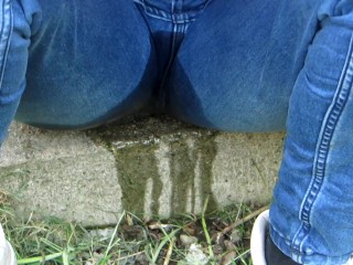 Pissing jeans in public street in sunny day