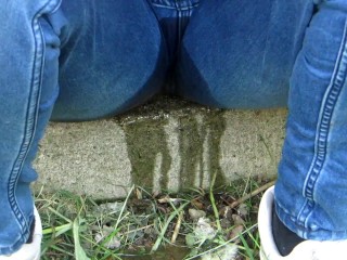 Pissing jeans in public street in sunny day