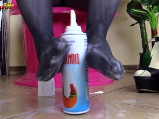 Brunette in pantyhose gives footjob to a cream tube