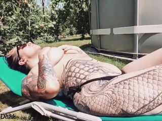 Hot inked girl playing with her big boobs next to the pool