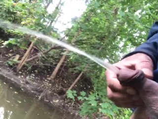 Moaning and a long piss from hard cock near the stream 