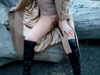 Alice in a coat and boots without a skirt and panties shows her welcoming pussy