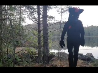 Fursuiter taking a piss against a tree