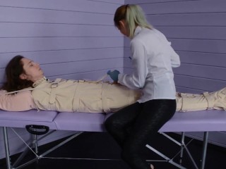 Figging with ginger and Foley bladder catheterization into bondage body bag. Medical play.