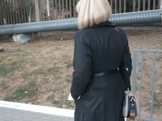 Slut walking in the park in a raincoat and black fishnet stockings with a white elastic band