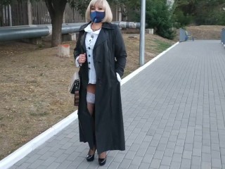 Slut walking in the park in a raincoat and black fishnet stockings with a white elastic band