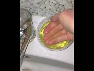 Girl Pissing into a container and plays urine with fingers. 3rd day of ovulation test