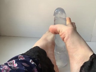 foot fetish. beautiful legs and a transparent dildo, on the windowsill