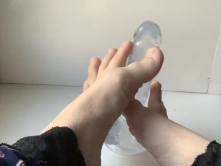 foot fetish. beautiful legs and a transparent dildo, on the windowsill