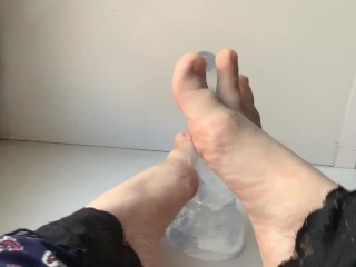 foot fetish. beautiful legs and a transparent dildo, on the windowsill